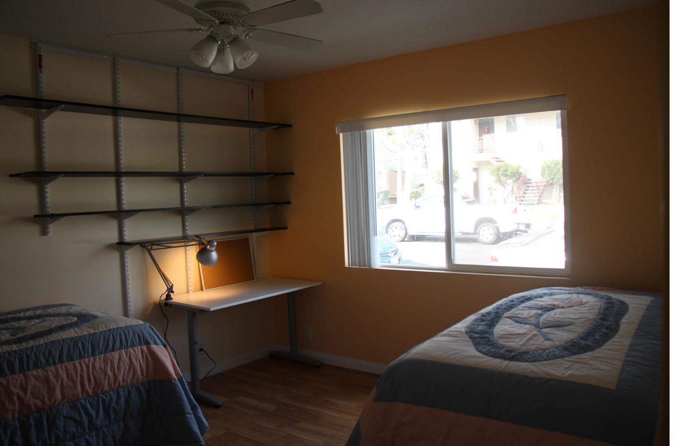 Bright bedroom window view dual study desks furnished student housing