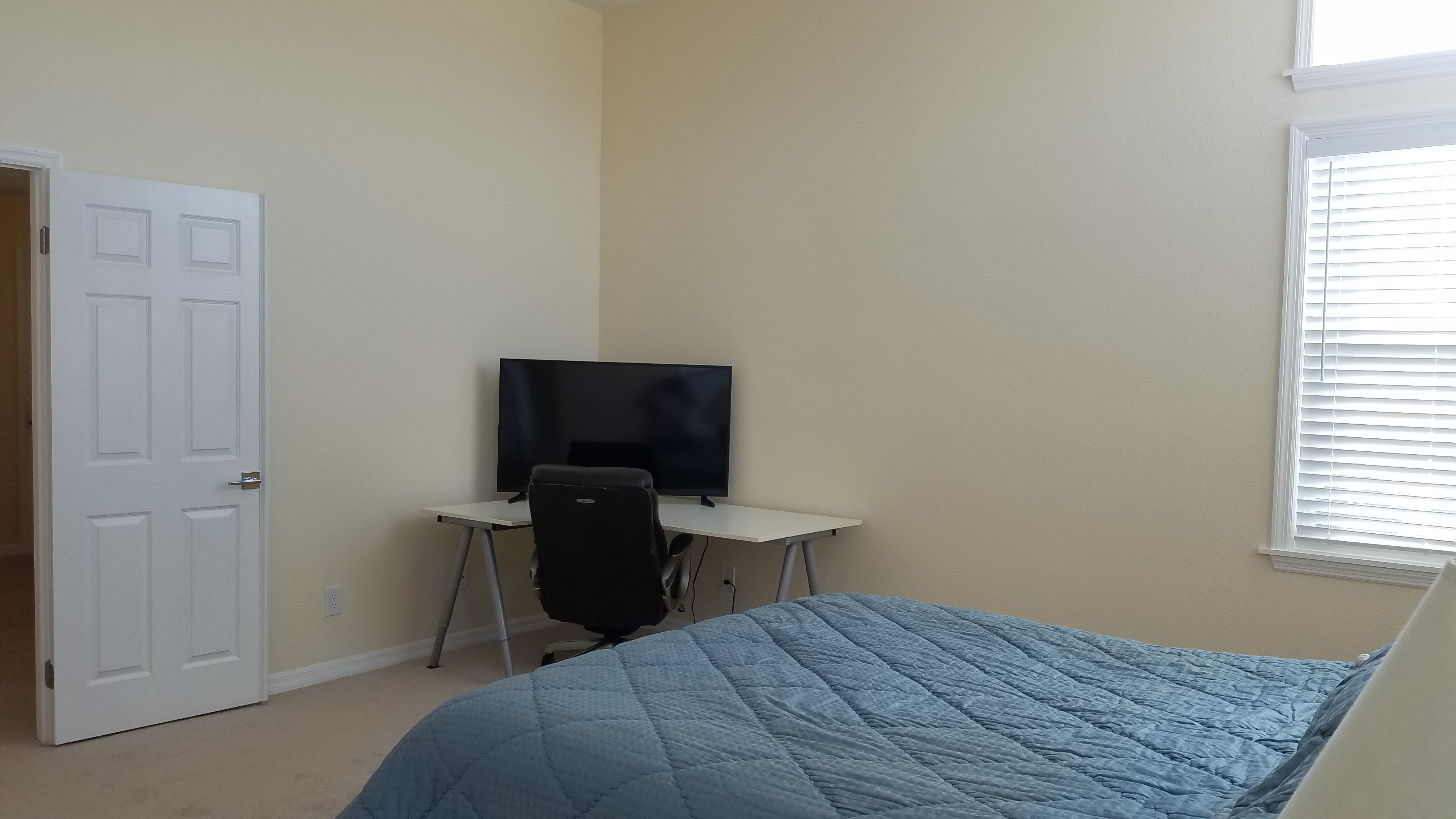 Master bedroom showing adjustable bed with lamp and arched en-suite bathroom entrance