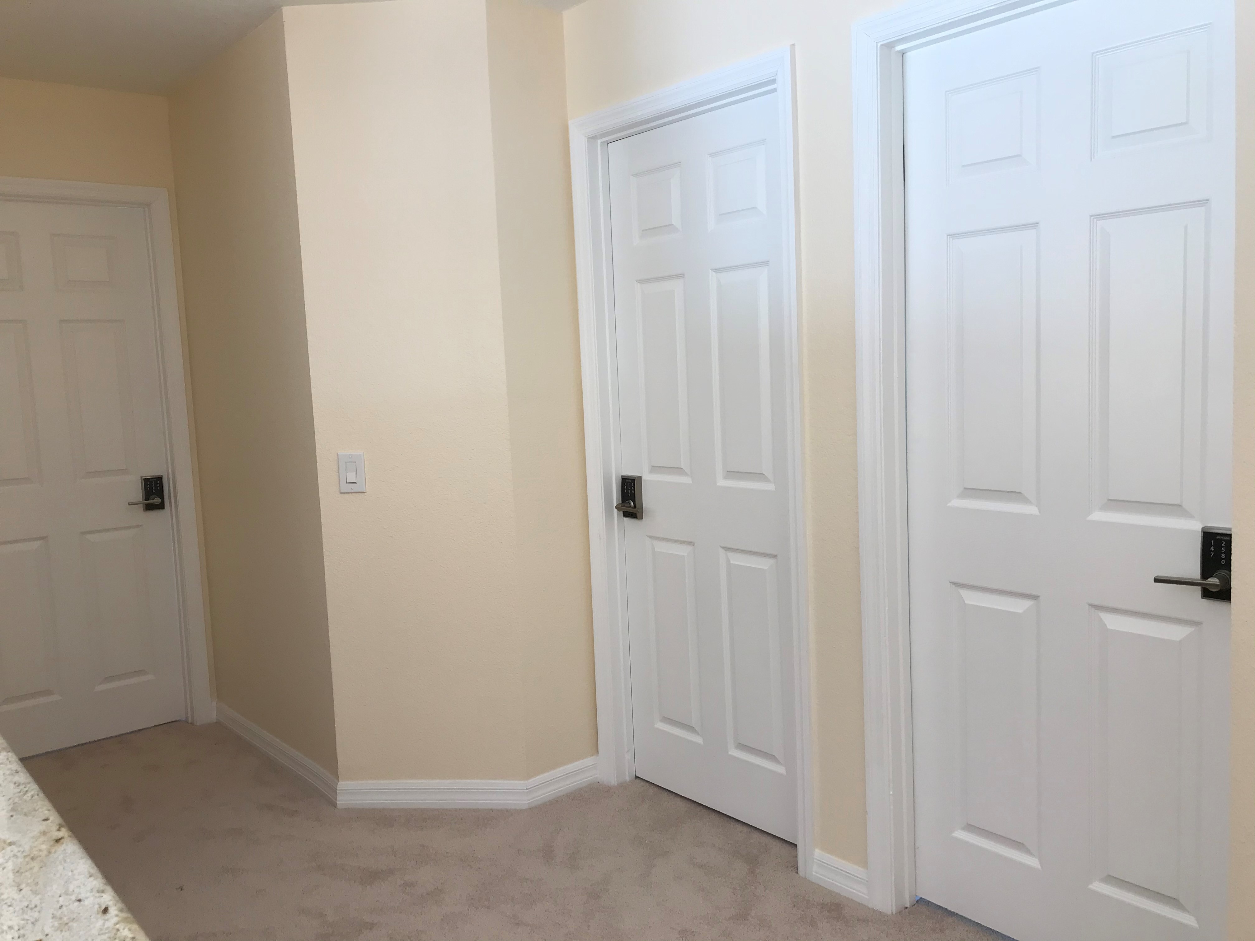 Upstairs hallway showing three bedroom doors each with private digital keypad locks